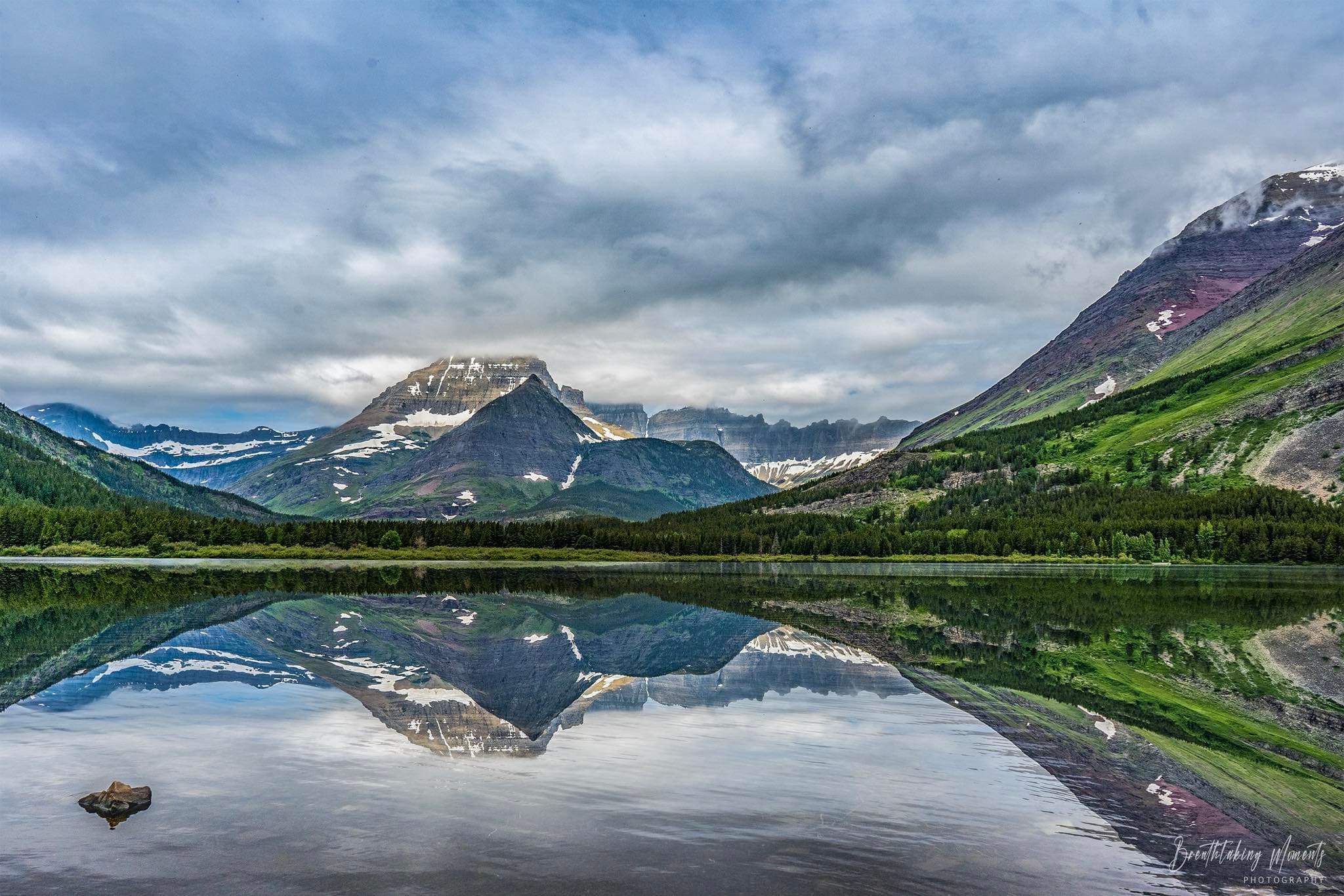 Perfect mirror reflection of mountain peaks in a still alpine lake
